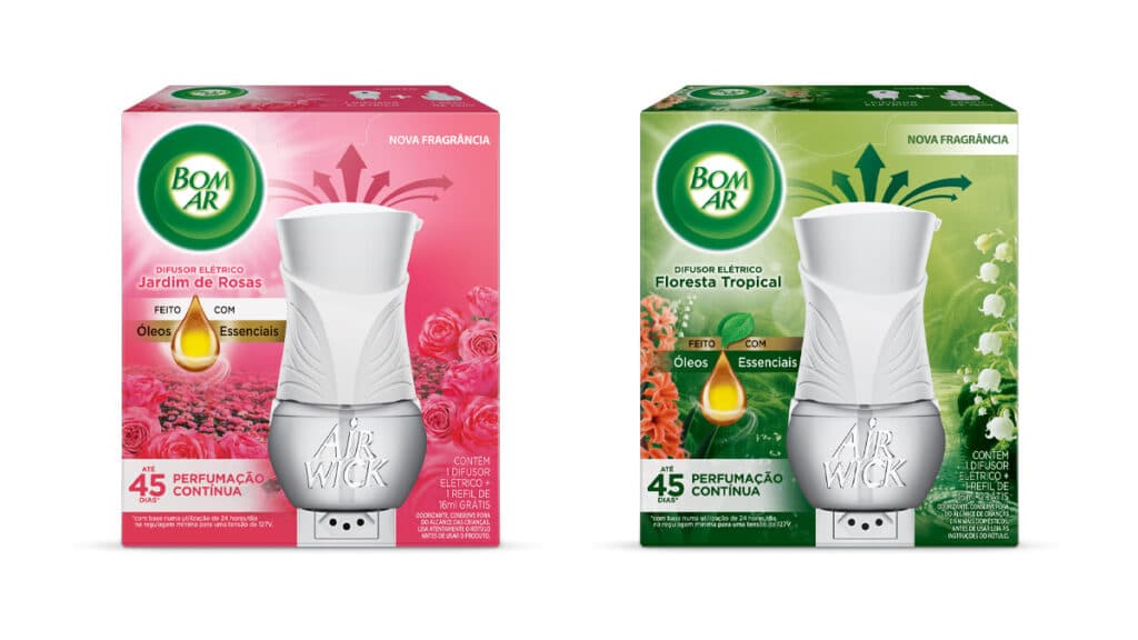 Foto de dois produtos da linha Difusor Elétrico Bom Ar: Jardim de Rosas e Floresta Tropical. O produto Jardim de Rosas está em uma embalagem rosa e destaca notas florais e frutadas. O produto Floresta Tropical está em uma embalagem verde, inspirado na flora brasileira, com notas aquáticas e cítricas.
