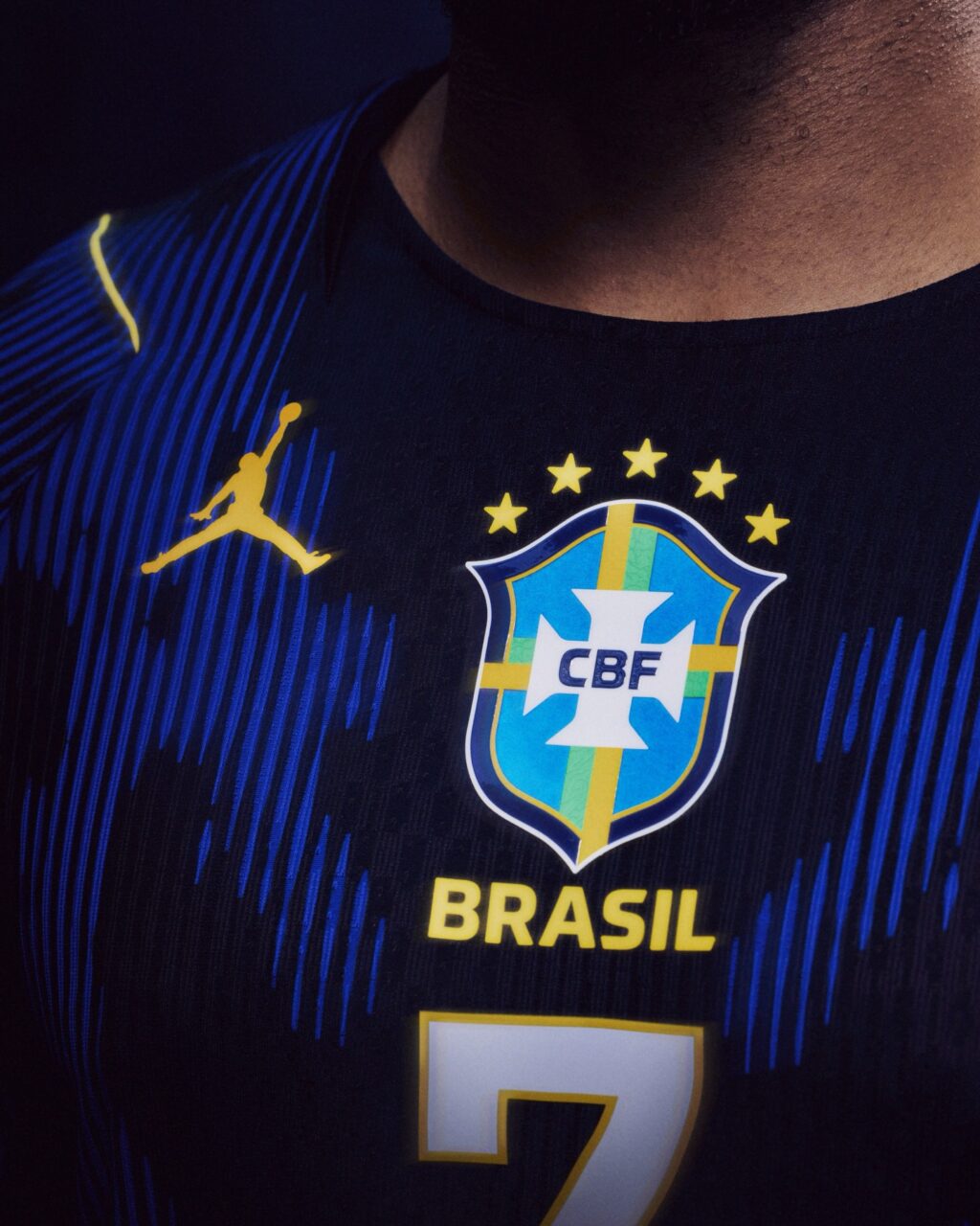 Close-up of a black football jersey featuring the Brasil national team badge, a yellow 'CBF' logo, and the number 7, with a Jordan Brand logo in yellow.