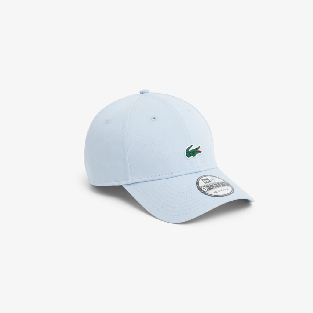 Light blue baseball cap with a green embroidered crocodile logo on the front.