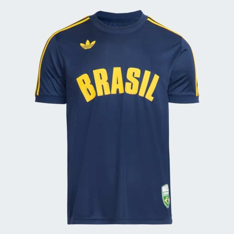 Uma camisa esportiva azul com a palavra 'BRASIL' em amarelo na frente e três listras amarelas nos ombros, com um pequeno logotipo da Adidas no canto superior esquerdo.