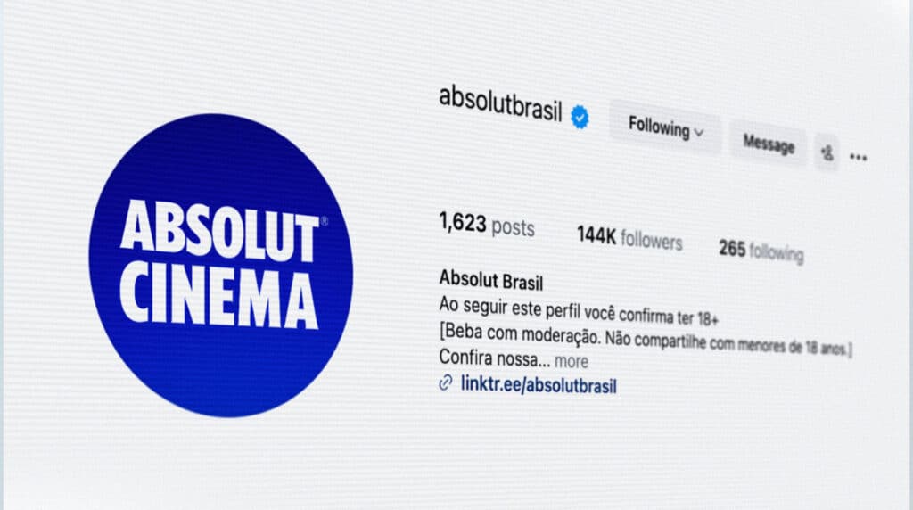 Captura de tela de um perfil do Instagram da Absolut Brasil com o logotipo da Absolut Cinema, exibindo 1.623 publicações, 144 mil seguidores e 265 pessoas que segue, com uma mensagem sobre verificação de idade.
