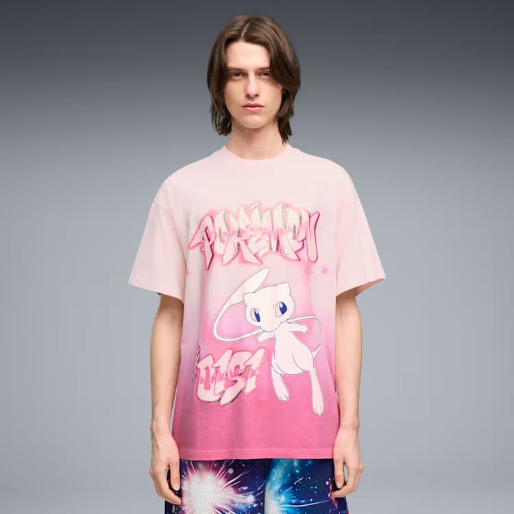 Um jovem vestindo uma camiseta rosa oversized com a estampa de um personagem Pokémon e texto estilizado, combinada com shorts estampados coloridos.
