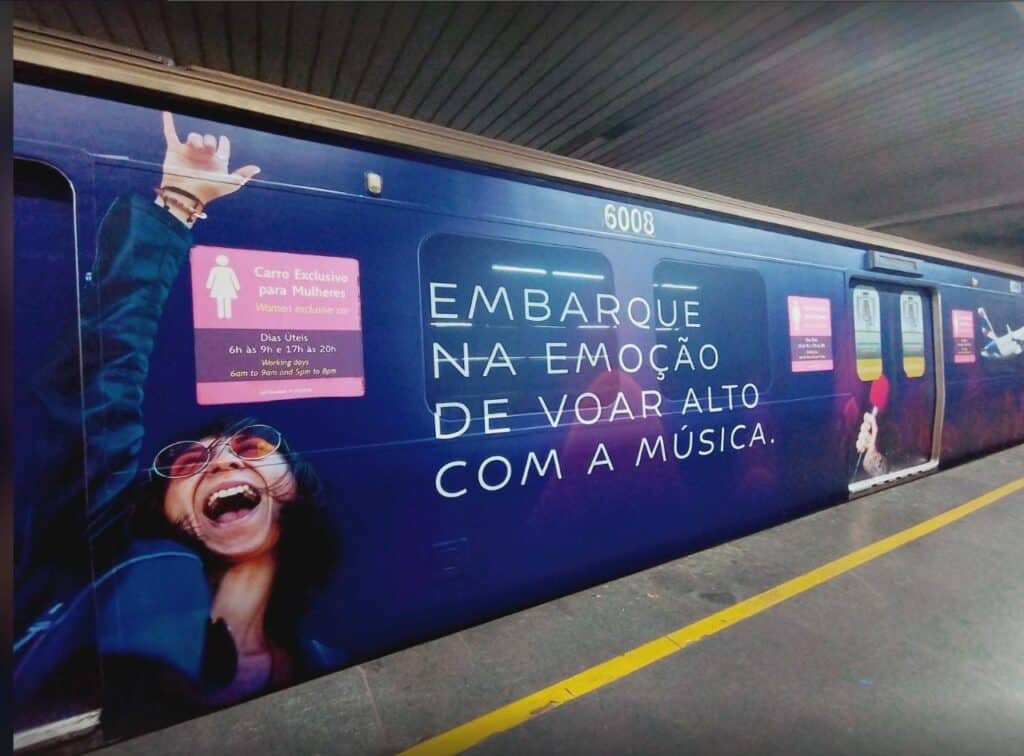 Trem da LATAM em estação com pintura “Embarque na emoção de viajar alto com a música” na lateral.