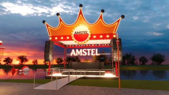 Palco iluminado da Amstel para o King’s Day, com coroa laranja ao fundo do céu ao entardecer