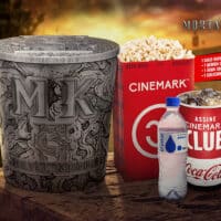Balde de pipoca colecionável da Cinemark para Mortal Kombat 2, com refrigerante e água sobre mesa