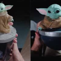 Balde 3D temático da Cinemark com Grogu, em formato do berço anti-gravidade, segurado por mãos.