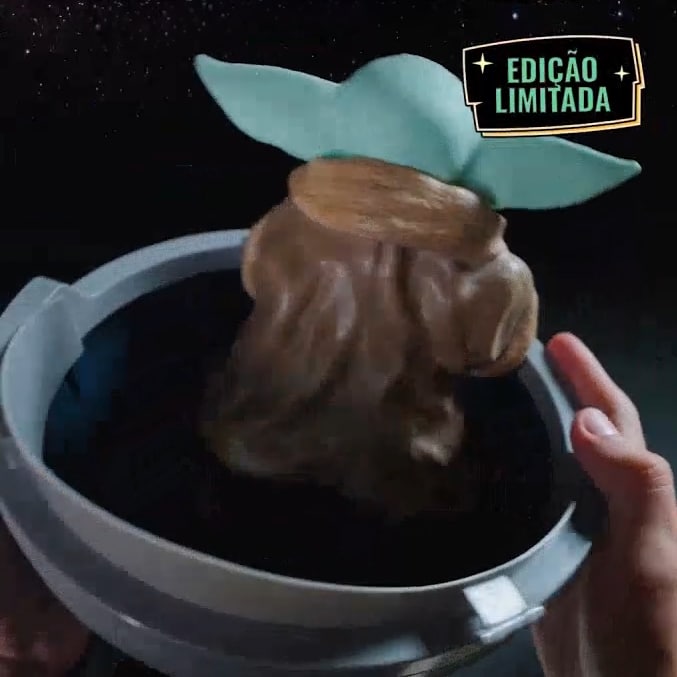 Balde de pipoca Grogu nas costas, com edição limitada, em ambiente escuro de cinema.
