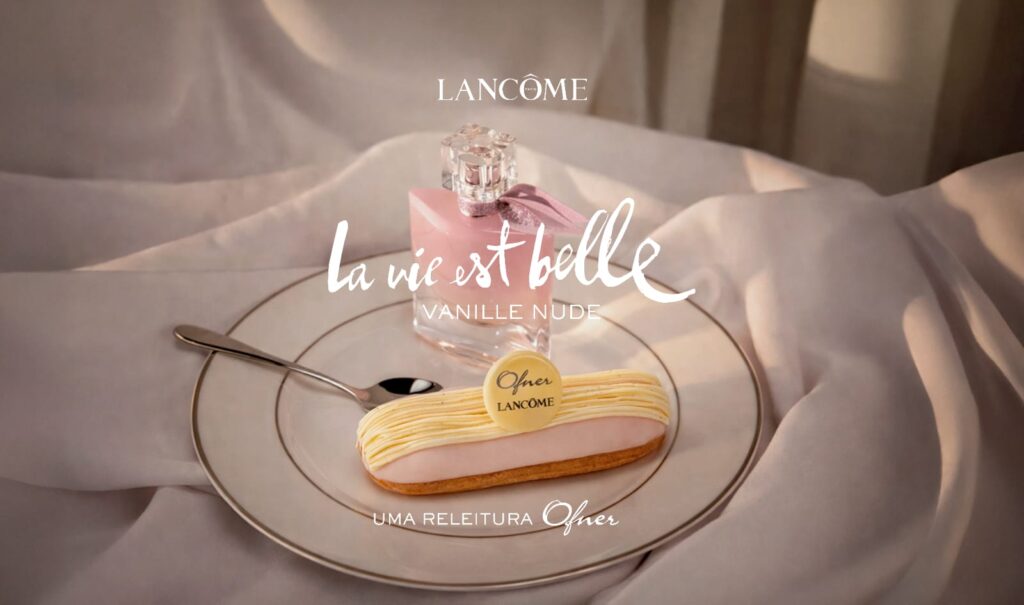 Eclair Ofner inspirado em La Vie Est Belle Vanille Nude Eclair da Ofner inspirado em La vie est belle Vanille Nude, com creme de baunilha e cobertura rosé, em prato dourado.