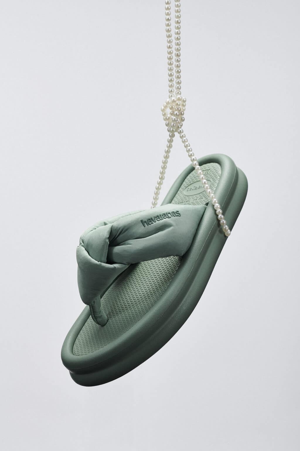 Sandália Havaianas verde em formato pendente com cordão de pérolas, tema O Diabo Veste Prada 2