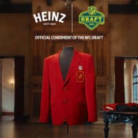 Jaqueta vermelha “Sr. 57” da Heinz em ambiente que lembra o Draft da NFL, com logotipos Heinz e NFL Draft ao fundo.