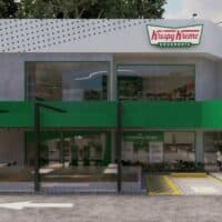 Fachada da Krispy Kreme Donuts em SP, com placa do logo e cobertura verde em frente à rua.