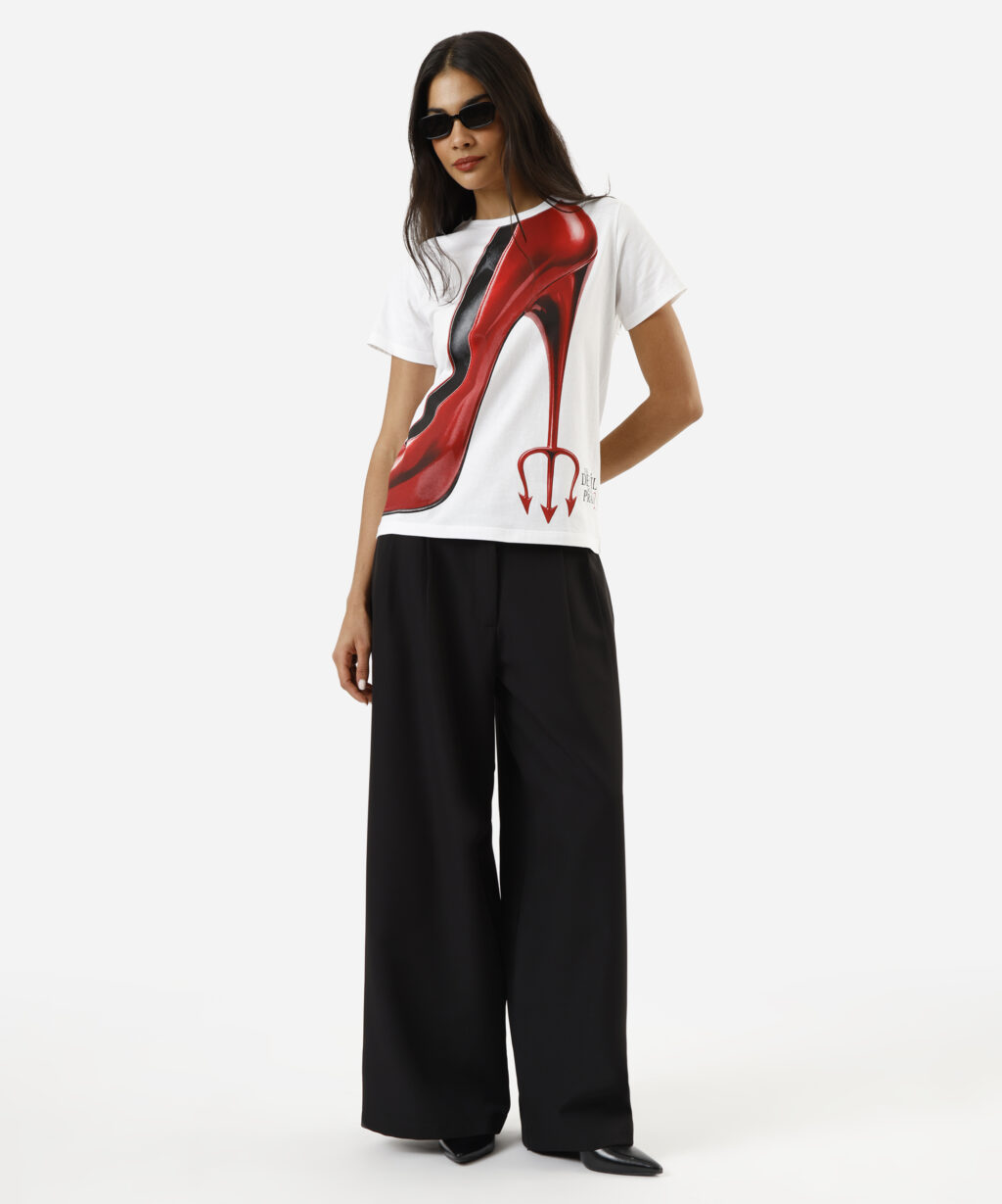 Modelo usando camiseta branca com estampa vermelha inspirada em O Diabo Veste Prada e calça preta