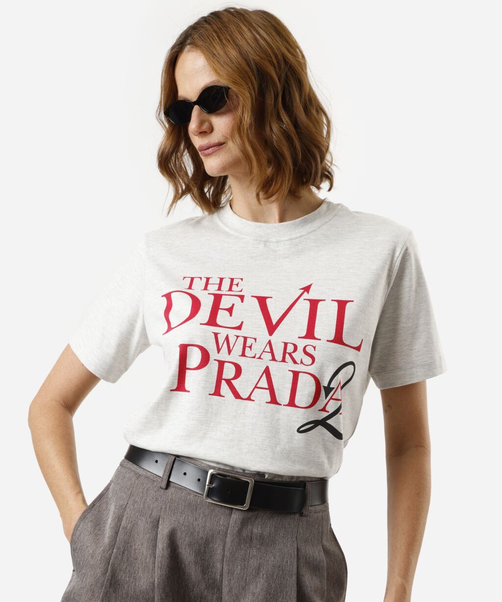 Modelo usando camiseta branca com estampa “The Devil Wears Prada” e óculos escuros, inspirada no filme