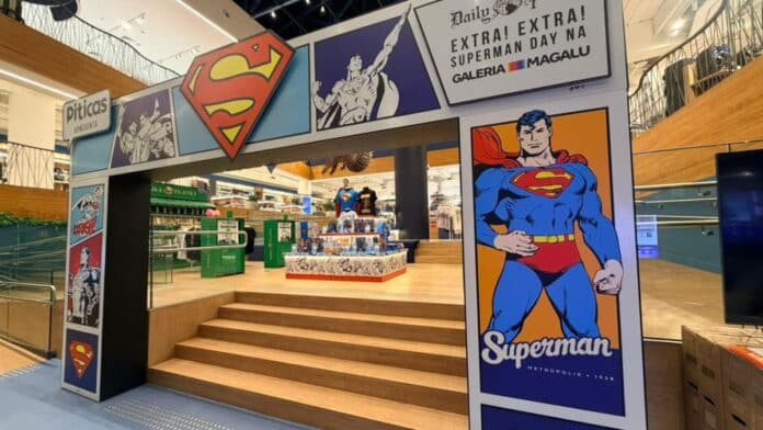 Galeria Magalu com decoração do Superman Day: pôster com o herói e letreiro Piticas em ambiente interno da loja.