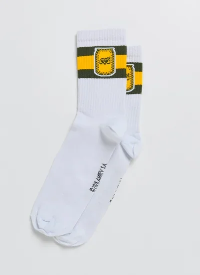 Par de meias brancas com detalhes em amarelo e preto e logo no punho, em coleção para a Copa do Mundo FIFA 2026.