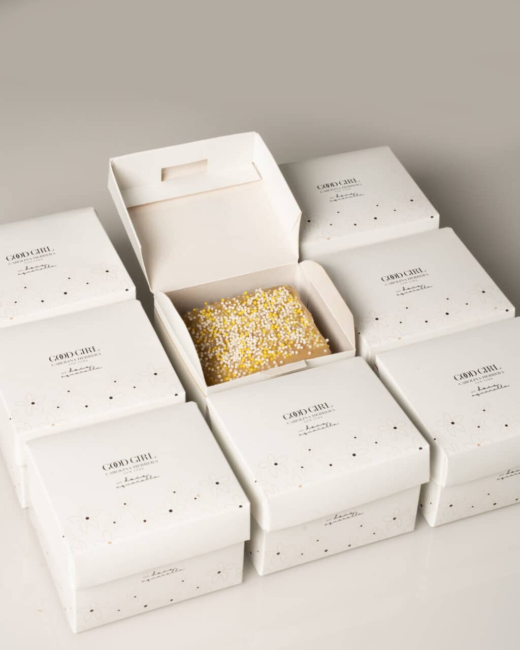 Caixas brancas da marca Carolina Herrera com detalhes e embalagem para evento do Good Girl Café em São Paulo.