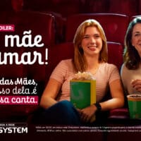 Mãe e filha no cinema com promoção do Dia das Mães da Cinesystem e mensagem de cortesia para mães.