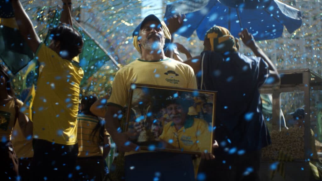 Torcedores comemoram em meio a confetes, com faixa e camisa da Volkswagen na campanha “Sonhos” para a Copa do Mundo.