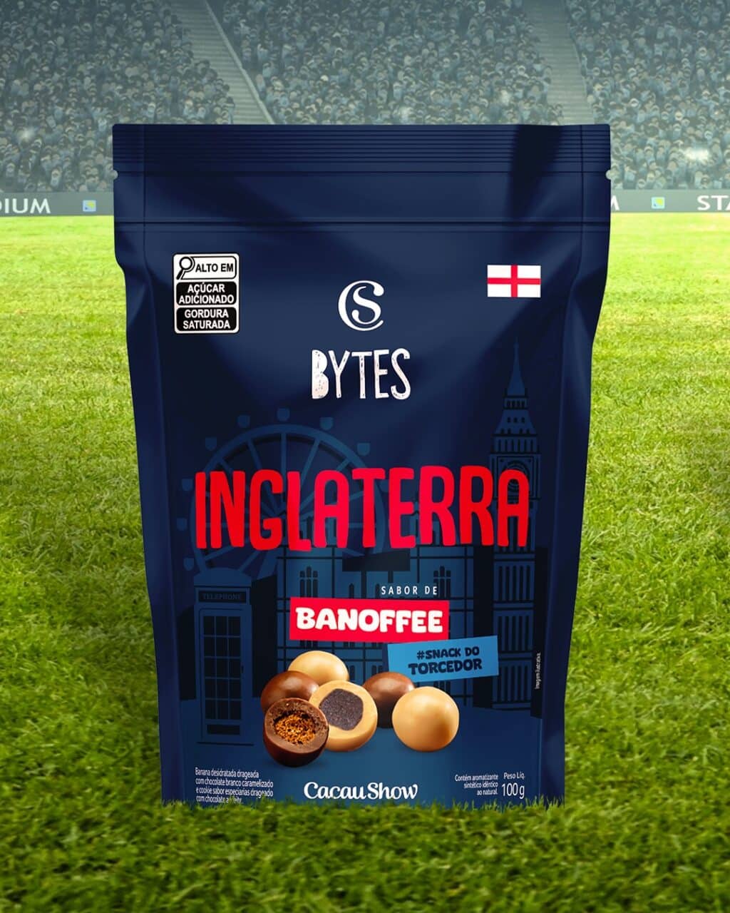 Embalagem de snack “Bytes Inglaterra” da Cacau Show com sabor de banoffee, em gramado de futebol.
