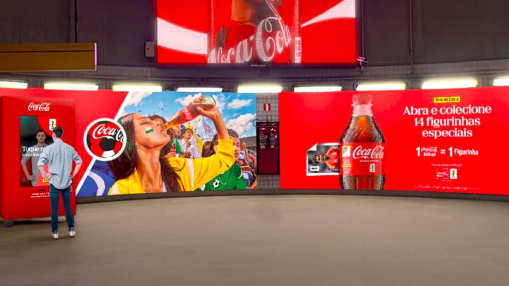 Campanha da Coca-Cola no metrô de São Paulo, com totens vermelhos e telão com marca Coca-Cola e pessoas em ação