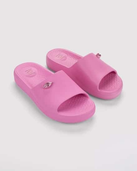Chinelo rosa com textura e logo na parte superior, modelo da collab Ipanema e Boca Rosa.
