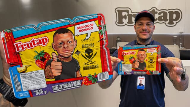 Homem em estande da Frutap, segurando embalagens de iogurte Morango saBOR/“Morago”.