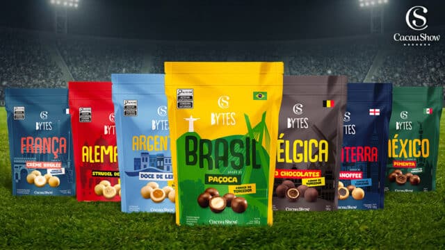 Embalagens da linha Cacau Show Bytes com temas de países da Copa do Mundo, incluindo Brasil, na frente de um estádio