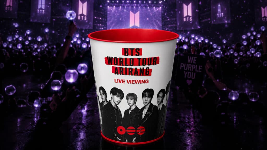 Balde colecionável do BTS com a arte “ARIRANG Live Viewing”, em cenário roxo do evento no Cinépolis.