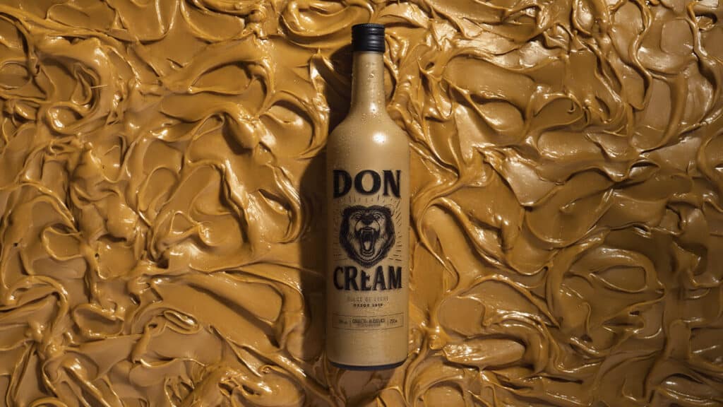 Garrafa Don Cream com rótulo “DON CREAM” em fundo dourado Garrafa de Don Cream em fundo dourado texturizado, com rótulo “DON CREAM”.