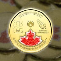 Moeda dourada canadense de 1 dólar com design da Copa do Mundo 2026, incluindo emblema e folha de bordo em mosaico