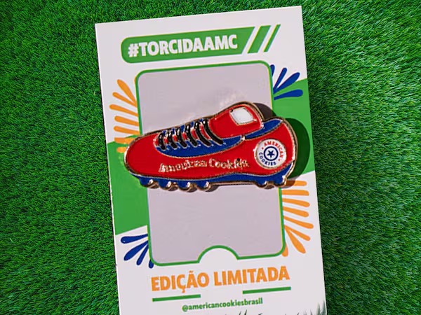 Tag da American Cookies em fundo de grama, com chuteira colorida e texto “Edição Limitada”.