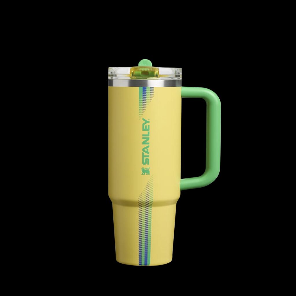 Copo térmico Stanley amarelo com tampa e alça verde, com design temático para Copa do Mundo 2026.