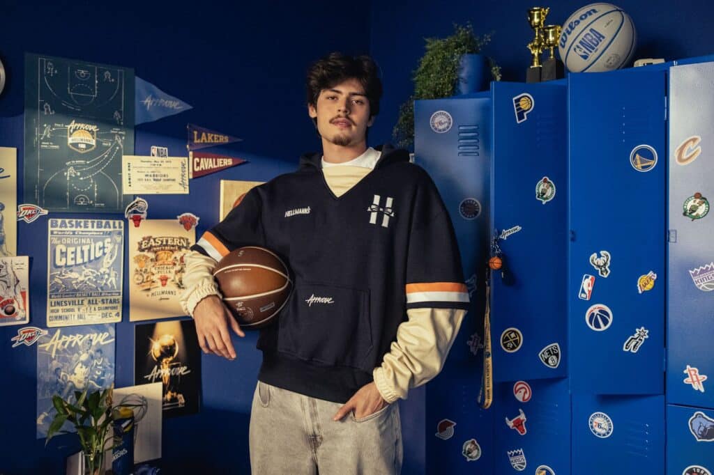 Modelo em ensaio com roupa da parceria Hellmann’s e Approve, segurando bola de basquete em cenário inspirado na NBA.
