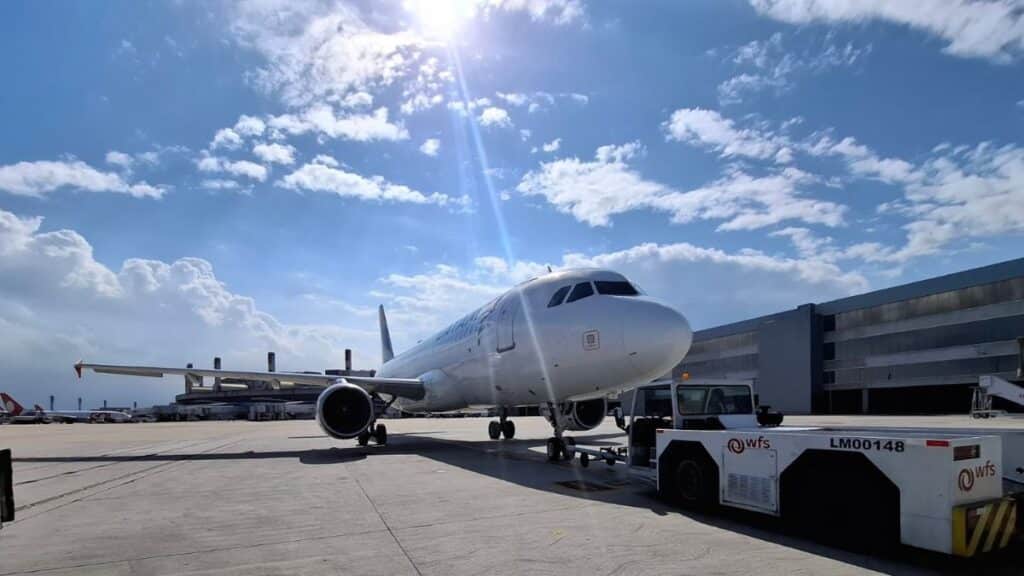 Aeronave da LATAM em pista no Rio de Janeiro, com equipamento de apoio ao lado.
