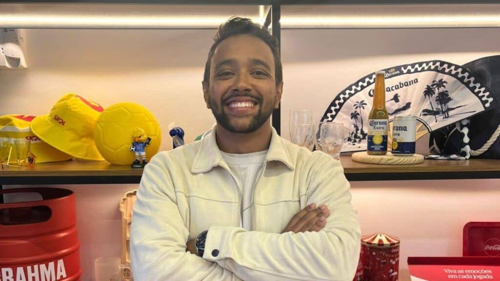 Luis Fernando S. Souza na Mood Group em ambiente de escritório Homem sorridente em escritório, com bolas e objetos decorativos ao fundo, em foto relacionada à Mood Group.