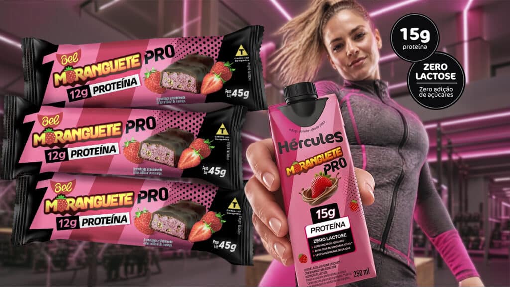 Moranguete Pro Bel: 12g de proteína e zero lactose Embalagens Moranguete Pro 12g proteína com sachê e uma bebida, ao lado de mulher em cenário promocional wellness da Bel.