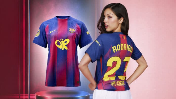 Modelo com camisa do Barcelona x Olivia Rodrigo, com design azul e vermelho e nome “RODRIGO” nas costas.