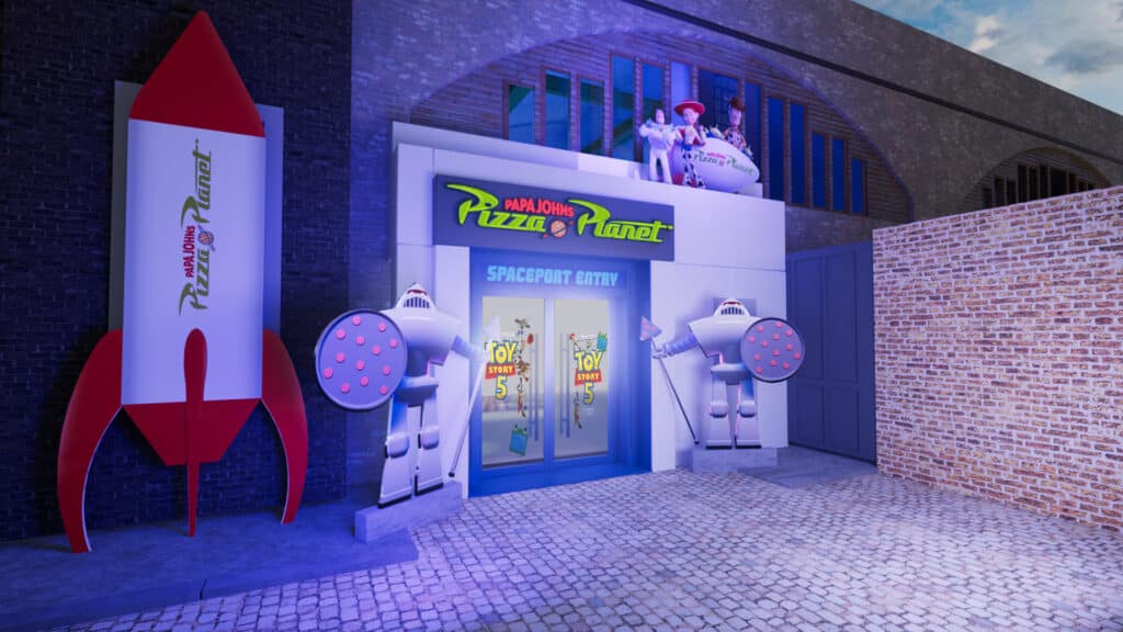 Fachada do Pizza Planet da Papa Johns em Londres, com pop-up temático de Toy Story 5 e nave em frente.
