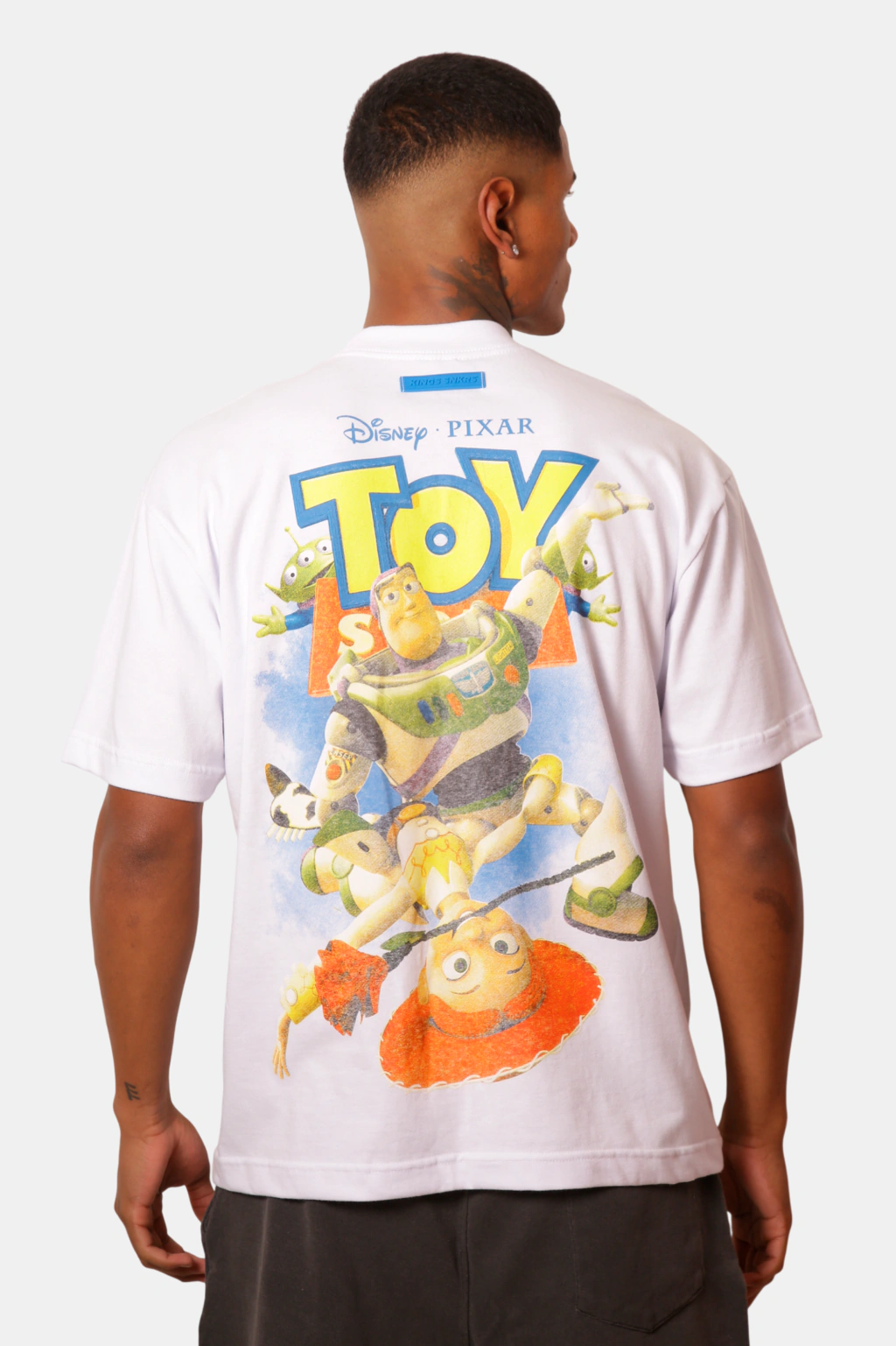 Camiseta branca com estampa temática de Toy Story, com personagens da Disney Pixar nas costas.