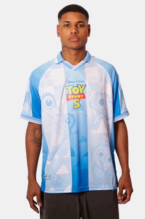Modelo vestindo camisa azul temática Toy Story 5 da Kings, com personagens e logo Pixar no uniforme