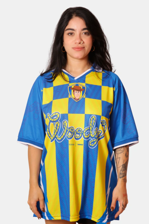 Modelo vestindo camisa esportiva azul e amarela com tema de Toy Story 5, estampa com personagens no centro