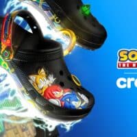 Par de Crocs temáticos do Sonic com solado grafismos e logo Sonic Crocs ao fundo azul
