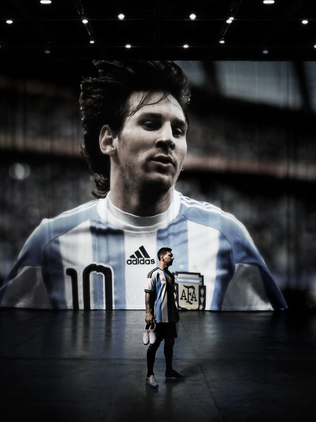 Lionel Messi em uniforme da Argentina em cenário de estádio, em foto de campanha da Adidas.