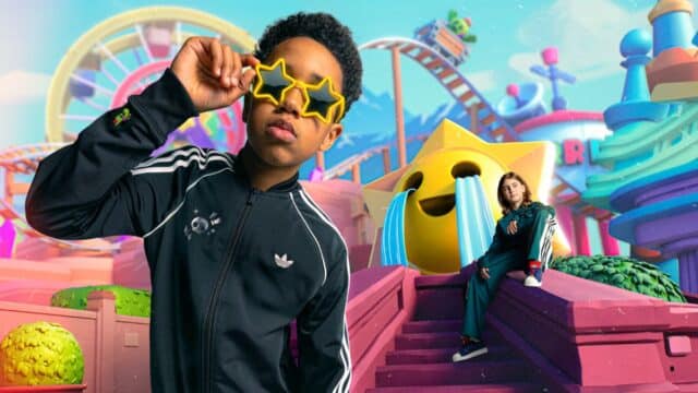 Imagem de divulgação da colaboração Adidas e Brawl Stars, com pessoa usando óculos estilizados em cenário de parque temático