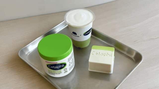 Produtos Cetaphil em bandeja, com pote verde, copo e sabonete em barra, sugerindo colaboração com café.