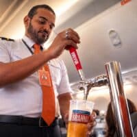 Comissário de bordo serve chope Brahma em trolley com chopeira a bordo de avião da GOL