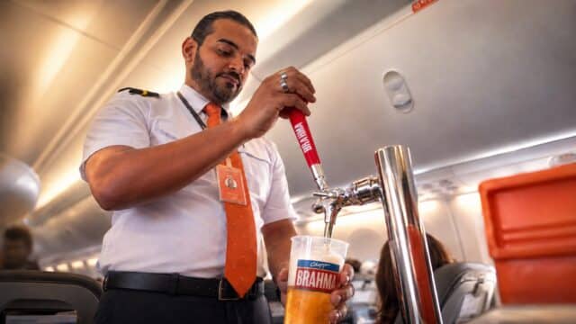 Comissário de bordo serve chope Brahma em trolley com chopeira a bordo de avião da GOL