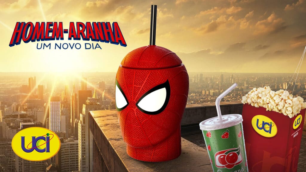 Copo em formato do Homem-Aranha ao lado de copo UCI com bebida, em cenário com a cidade ao fundo.