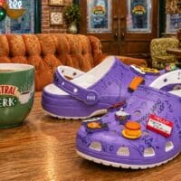 Sandálias Crocs roxas da coleção Friends, com Jibbitz e detalhes inspirados na série em ambiente decorado