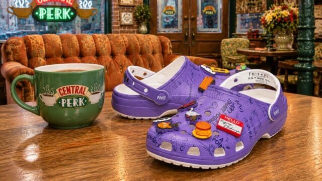 Sandálias Crocs roxas da coleção Friends, com Jibbitz e detalhes inspirados na série em ambiente decorado